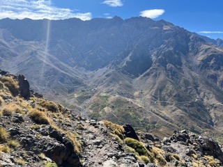 Rocky trail overlooking the green Aït Bouguemez Happy Valley in the Central High Atlas, Morocco