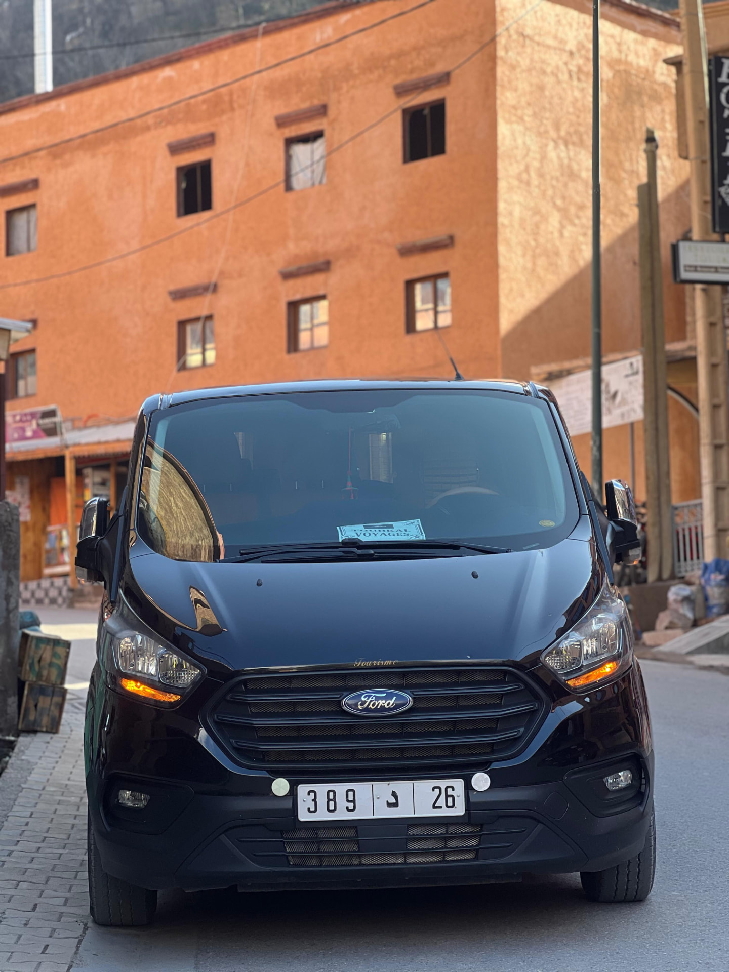 Private tour vehicle parked beside terracotta Atlas mountain buildings
