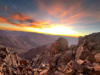 Orange sunrise over rugged High Atlas ridgelines near Mount Toubkal